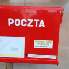 Czerwona skrzynka pocztowa z napisem "POCZTA". Obok etykieta z adresem i informacją, czy żona może odebrać list polecony z sądu.