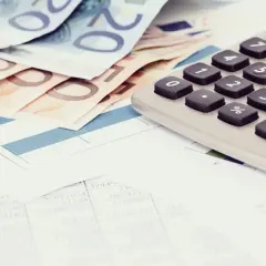 Euro banknoty, kalkulator i dokumenty finansowe. Czy z komornikiem można się dogadać? Analiza wydatków i możliwości.