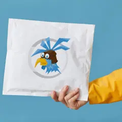 Ręka w żółtej kurtce trzyma białą paczkę z logo niebieskiego ptaka w goglach. To symbol szybkiego operatora pocztowego.