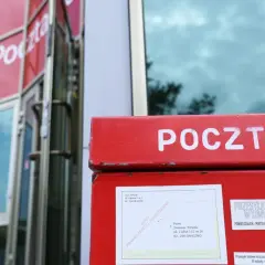 Czerwona skrzynka pocztowa z napisem "POCZTA". Obok niej informacja, ile listów poleconych czeka na poczcie do odbioru.
