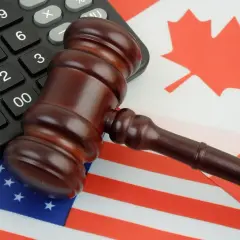 Młotek sędziowski na flagach USA i Kanady, symbolizujący rodzaje cła i handel międzynarodowy.