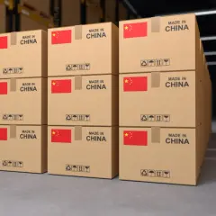 Pudełka z napisem "MADE IN CHINA" i flagą Chin w magazynie, gotowe do wysyłki kurierem.