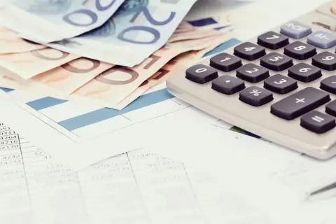 Euro banknoty, kalkulator i dokumenty finansowe. Czy z komornikiem można się dogadać? Analiza wydatków i możliwości.