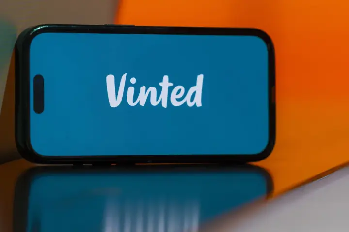 Telefon z logo Vinted. Dowiedz się, jak założyć konto na Vinted i zacznij sprzedawać lub kupować ubrania.