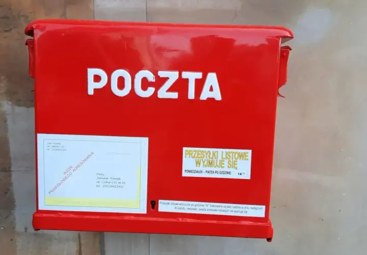 Czerwona skrzynka pocztowa z napisem "POCZTA". Obok etykieta z adresem i informacją, czy żona może odebrać list polecony z sądu.