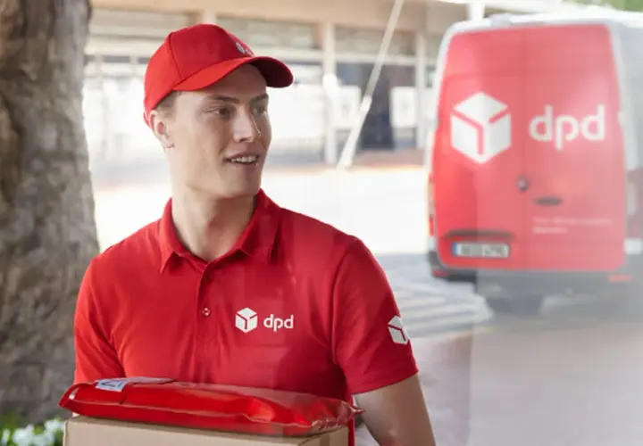 Kurier DPD z paczką w czerwonym opakowaniu, obok czerwonego vana. Czy to uszkodzona paczka DPD?