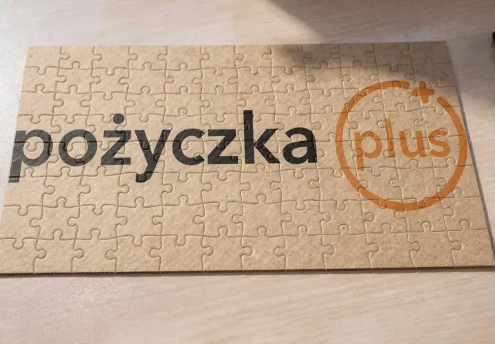 Puzzle z napisem "pożyczka plus". Każdy element układanki tworzy całość, tak jak raty tworzą spłatę pożyczki.
