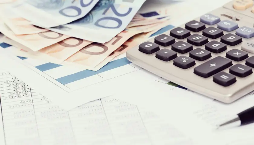 Euro banknoty, kalkulator i dokumenty finansowe. Czy z komornikiem można się dogadać? Analiza wydatków i możliwości.
