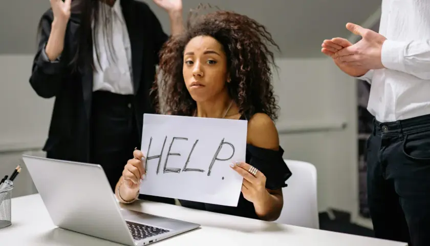 Kobieta z kartką "HELP" szuka sposobu, jak pozbyć się chwilówek. Wokół niej widać zaniepokojonych ludzi.