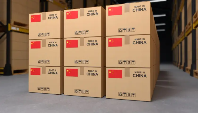 Pudełka z napisem "MADE IN CHINA" i flagą Chin w magazynie, gotowe do wysyłki kurierem.