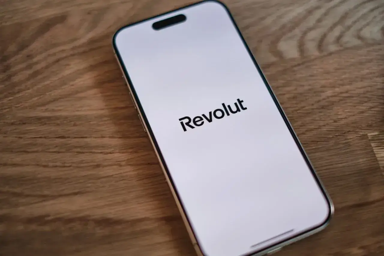 Smartfon z logo Revolut na białym ekranie, gotowy do użycia jako wpłatomat Revolut.